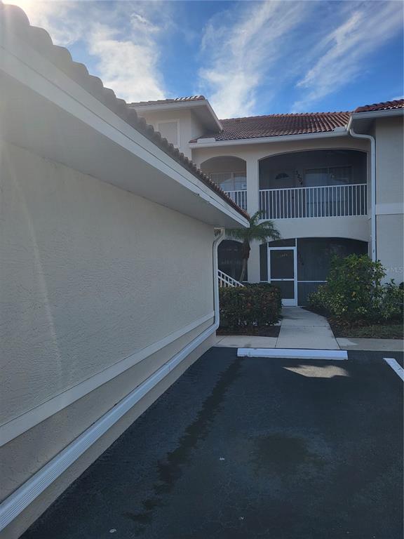 A two-story residential building with a parking space and a walkway leading to entrances — 3104 L PAVIA BOULEVARD UNIT 3104, VENICE, FL