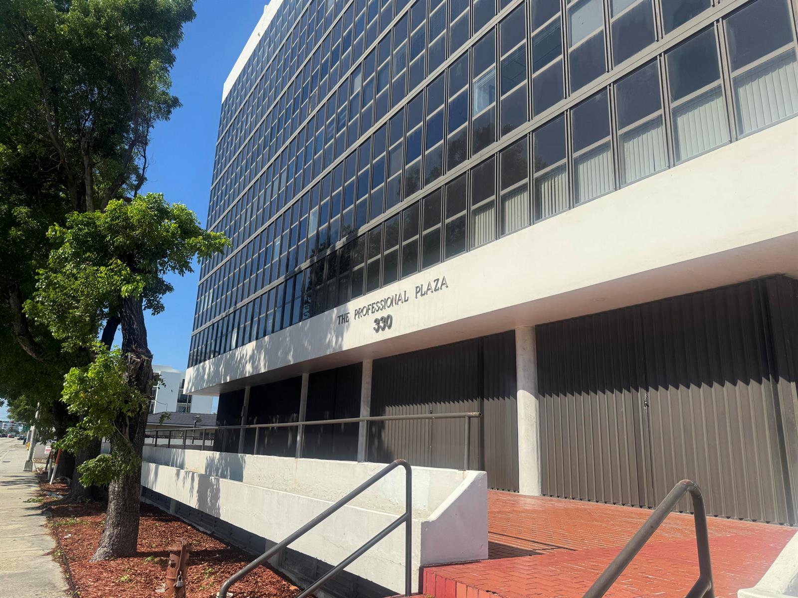 A low-angle exterior view of a multi-story office building with a glass facade and entrance — 330 SW 27th Avenue # 309, Miami FL 33135, MIAMI, FL