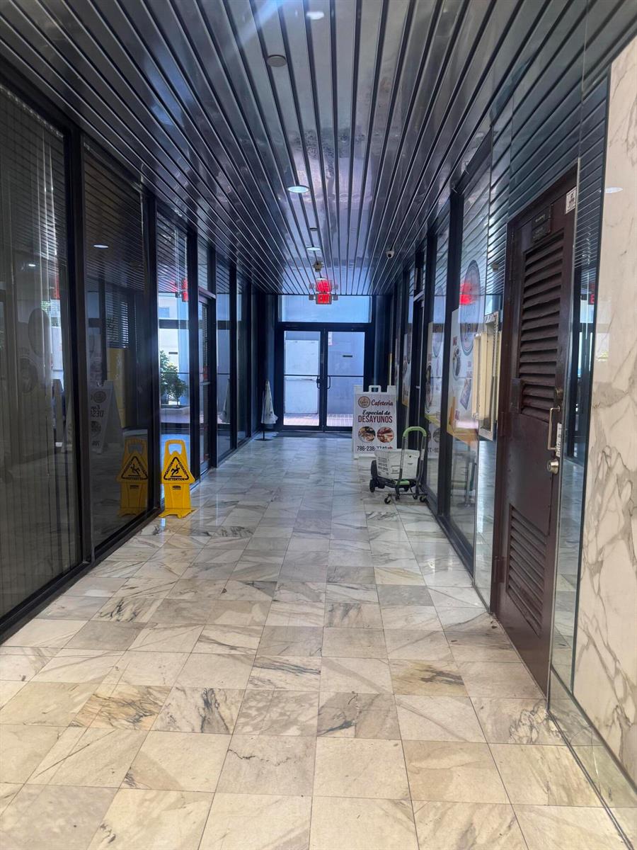 A narrow hallway with marble tile flooring leads to a glass door at the end — 330 SW 27th Avenue # 309, Miami FL 33135, MIAMI, FL