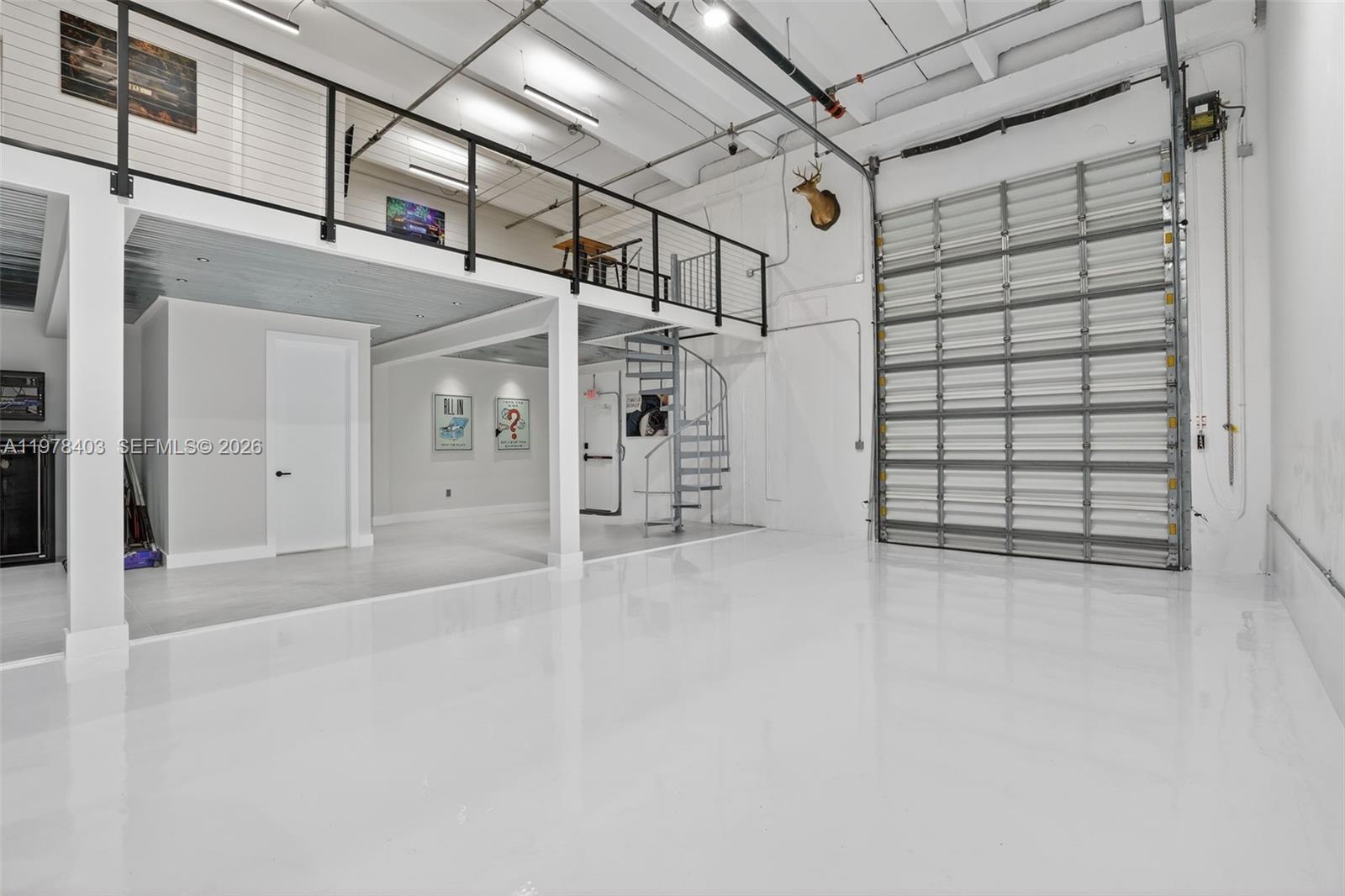 A high-ceilinged industrial space features a white epoxy floor, a loft level, and a spiral staircase — 13500 SW 134th Ave # 4A, Miami FL 33186, MIAMI, FL