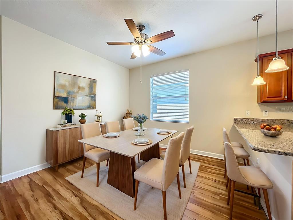 A dining room features a wooden table with six chairs, a sideboard, and pendant lighting — 4052 SERENA LANE, CLERMONT, FL