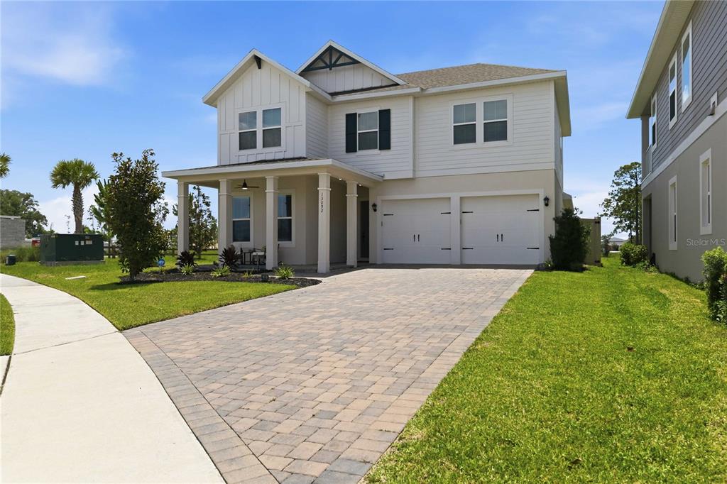 A two-story house with white siding, a covered front porch, and a paved driveway — 13092 SUNRISE HARVEST DRIVE, WINTER GARDEN, FL