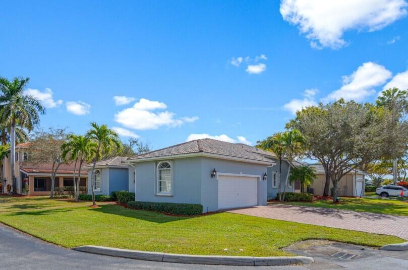 A light blue single-story house with a two-car garage and palm trees on a lawn — 2570 SE 4th Place, Homestead FL 33033, HOMESTEAD, FL