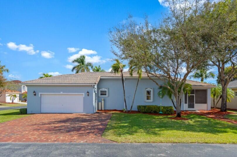A single-story light blue house with a brick driveway, two-car garage, and a screened-in porch — 2570 SE 4th Place, Homestead FL 33033, HOMESTEAD, FL