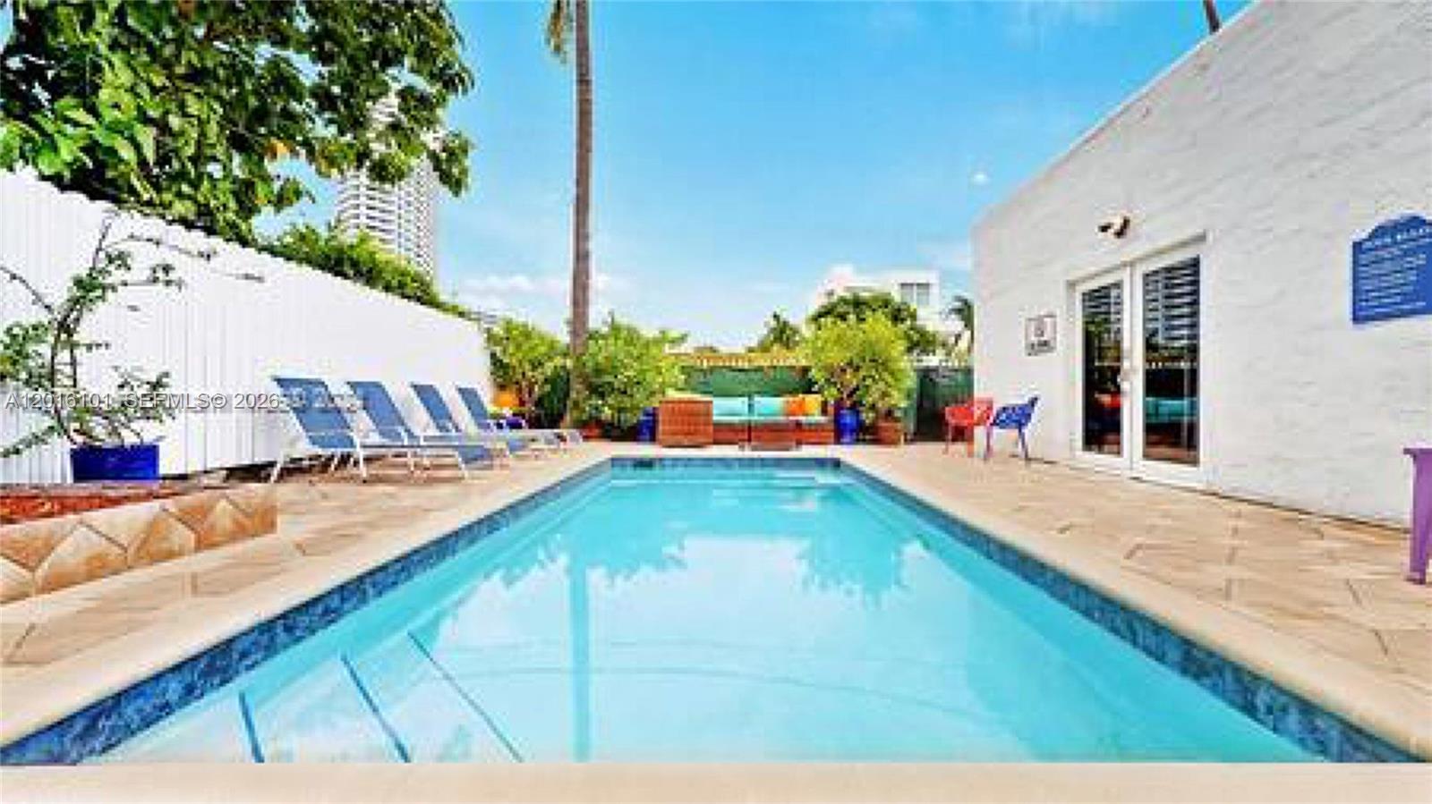 A rectangular swimming pool sits on a paved patio next to a white building — 1400 West Ave, Miami Beach FL 33139, MIAMI BEACH, FL