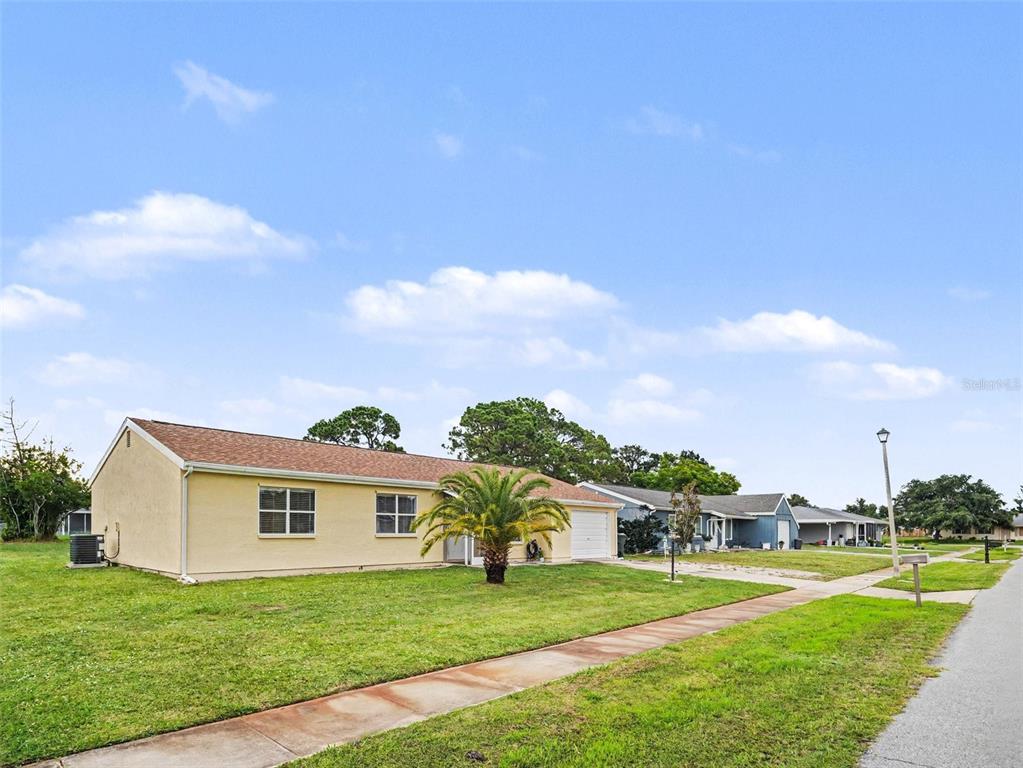A single-story, light yellow house with a palm tree in the front yard — 2473 FAIRBROOK STREET, NORTH PORT, FL