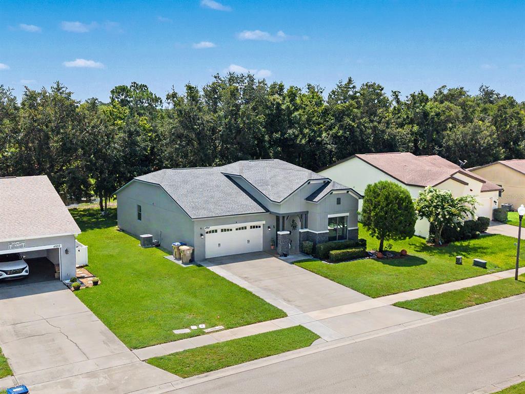 An aerial view of a suburban single-story house with a two-car garage and green lawn — 4824 ASHURST STREET, KISSIMMEE, FL