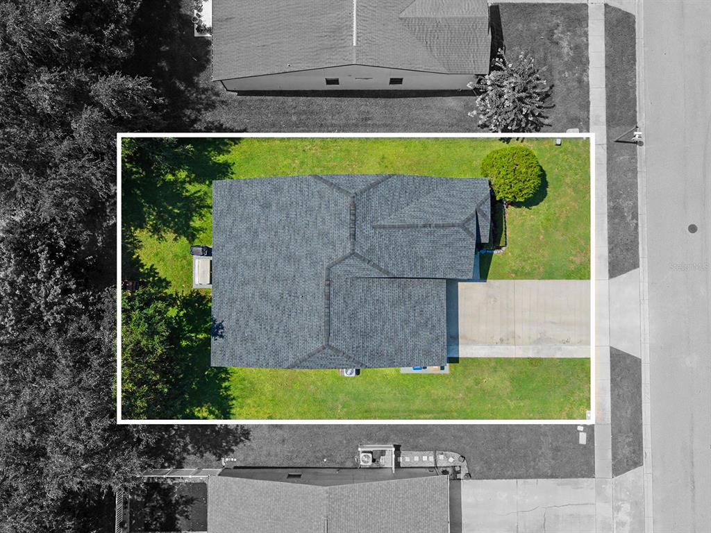 An aerial view shows a residential house with a shingled roof and surrounding lawn — 4824 ASHURST STREET, KISSIMMEE, FL