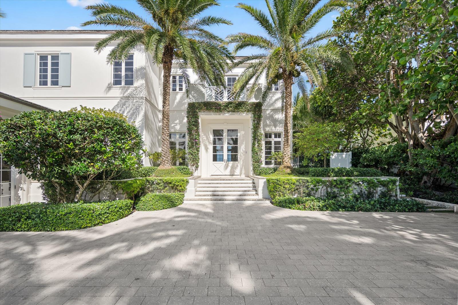 A white two-story house features a paved driveway, palm trees, and a vine-covered entryway — 3501 N Ocean Boulevard, Gulf Stream FL 33483, GULF STREAM, FL