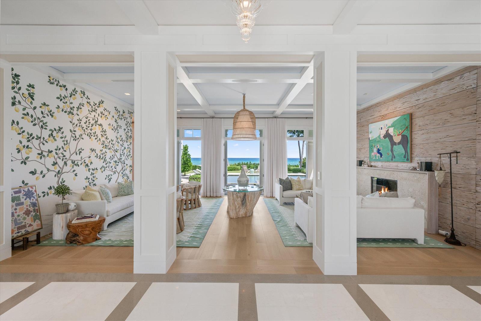 A bright, open-concept living area features a lemon-patterned wall, wood-paneled fireplace, and ocean views — 3501 N Ocean Boulevard, Gulf Stream FL 33483, GULF STREAM, FL
