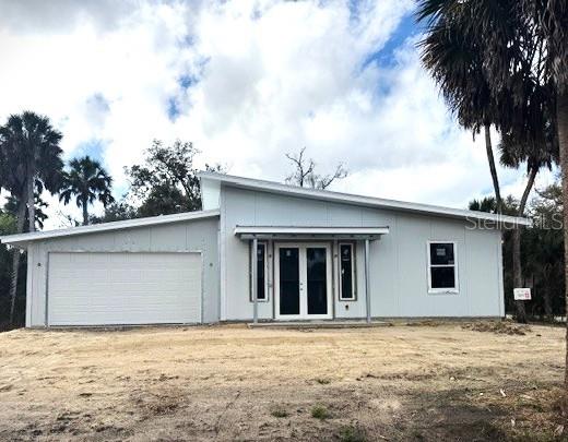 A single-story house with light gray siding, a shed roof, and an attached garage — 16411 BAUERS AVENUE, PORT CHARLOTTE, FL