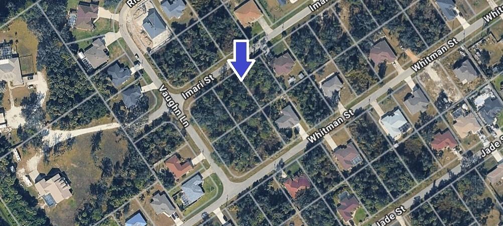 This aerial map shows a vacant, wooded residential lot marked by an arrow on a street — IMARI STREET, NORTH PORT, FL