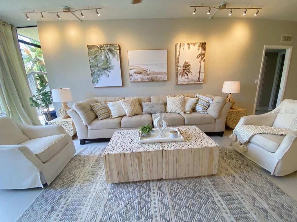 A living room features a beige sofa, two armchairs, and a dual-block wooden coffee table — 5855 MIDNIGHT PASS ROAD UNIT 108, SARASOTA, FL