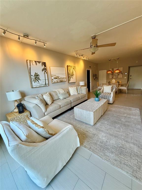 A living room features a beige sectional, an armchair, a coffee table, and track lighting — 5855 MIDNIGHT PASS ROAD UNIT 108, SARASOTA, FL
