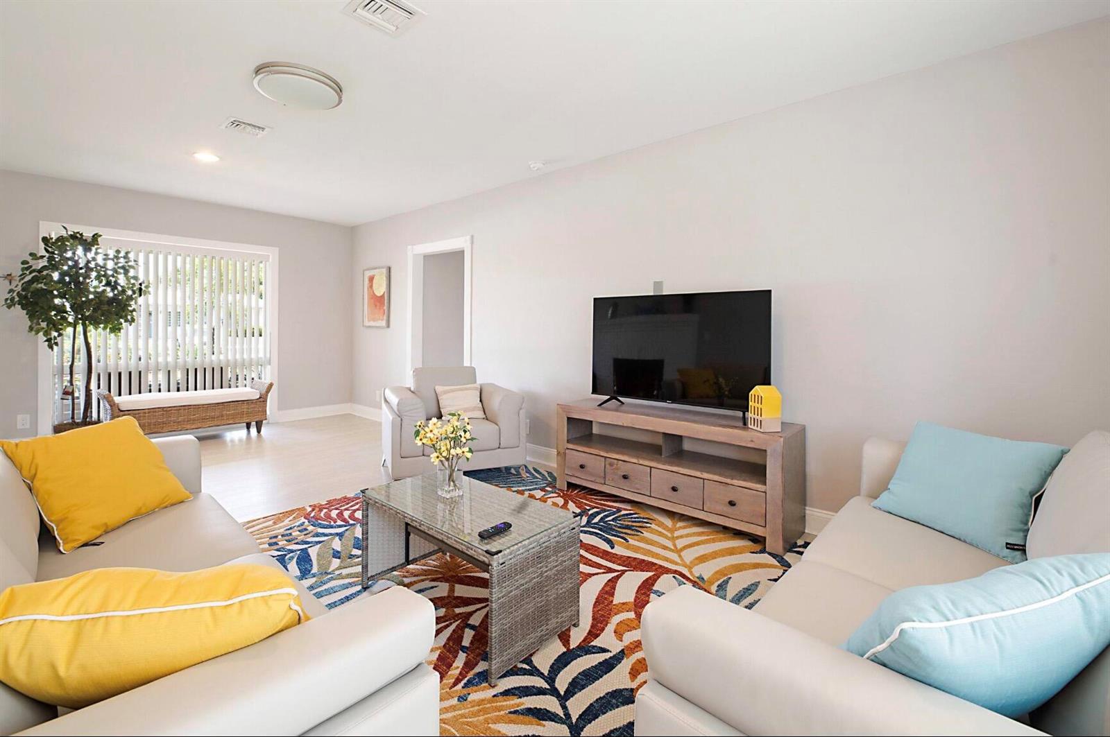A living room features light gray walls, a patterned area rug, and two neutral sofas — 2740 SE 1st Court, Pompano Beach FL 33062, POMPANO BEACH, FL
