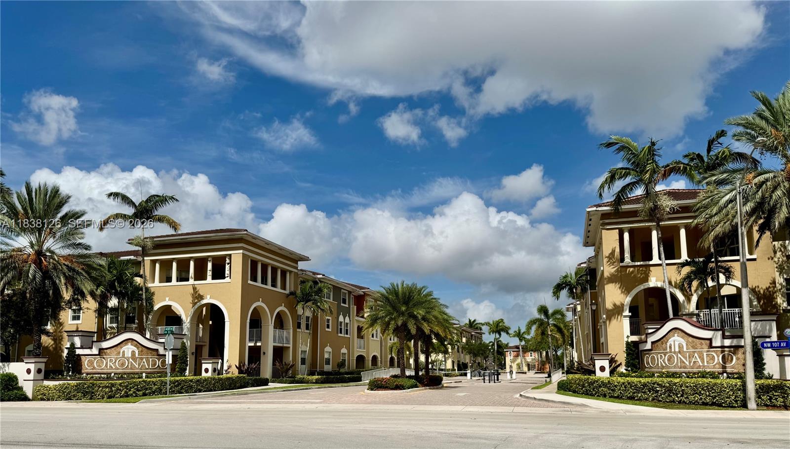 The exterior view shows two tan apartment buildings with palm trees and Coronado signage — 8800 NW 107th Ct # 202, Doral FL 33178, DORAL, FL