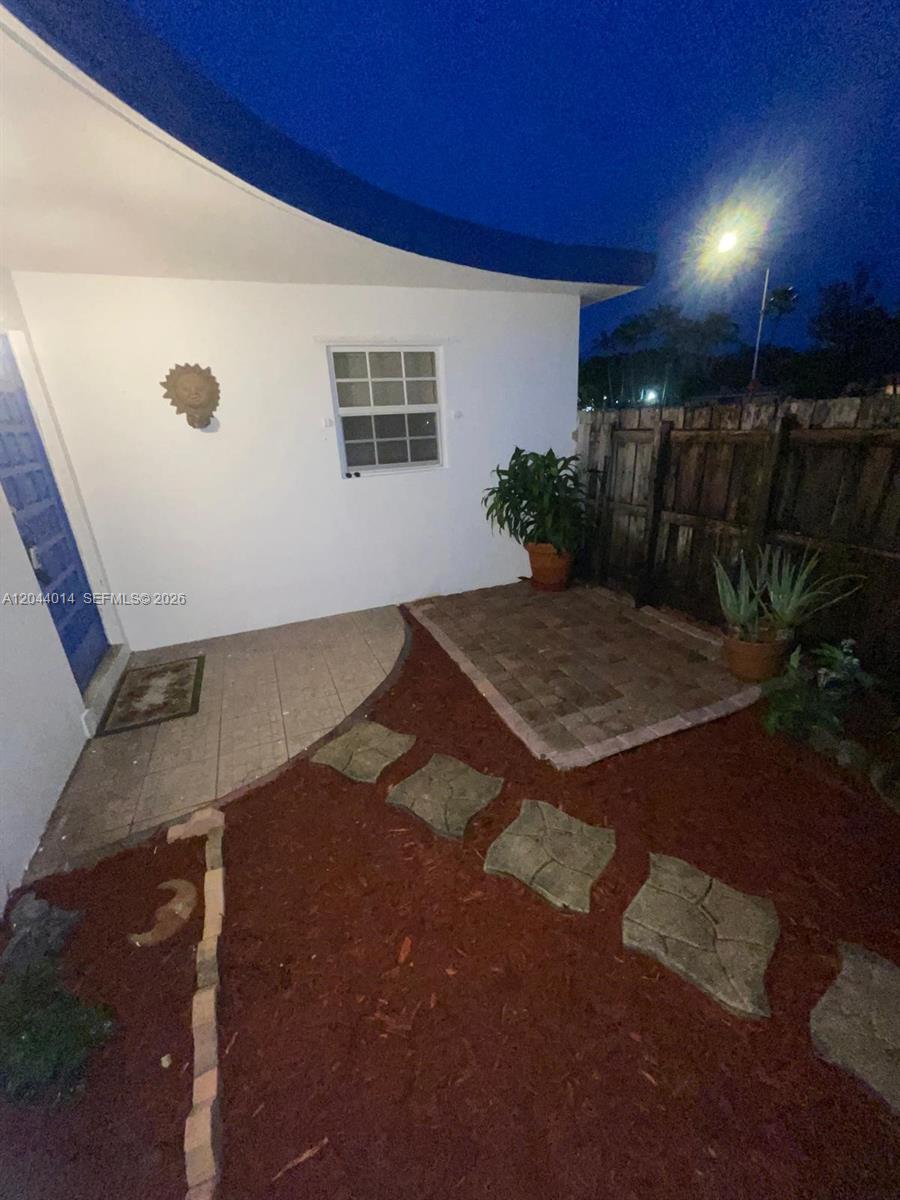 A small patio area features a brick-paved section, stepping stones, and a blue door — 6461 Miramar Pkwy, Miramar FL 33023, MIRAMAR, FL