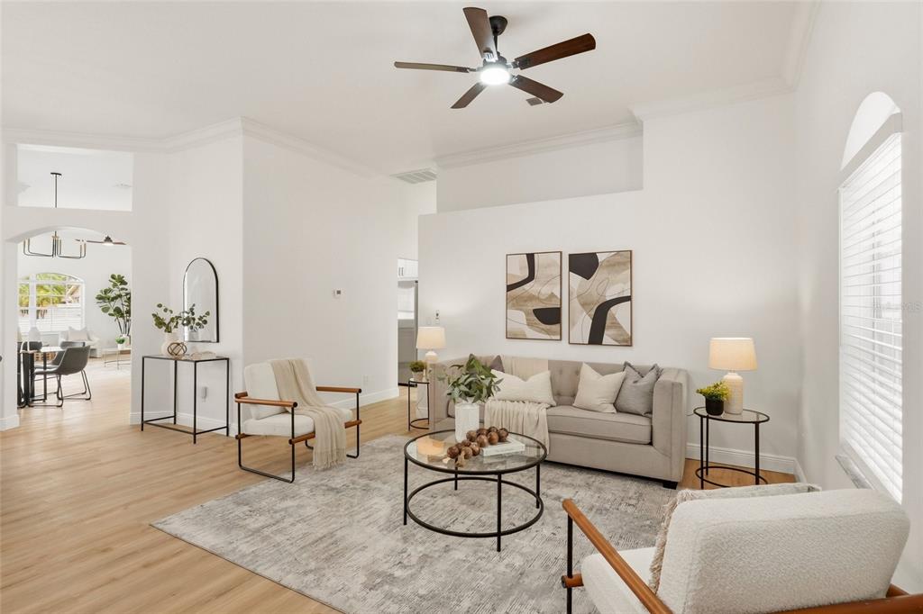 A bright living room features a beige sofa, two armchairs, a coffee table, and wood flooring — 9238 SEA OAKS COURT, SEMINOLE, FL