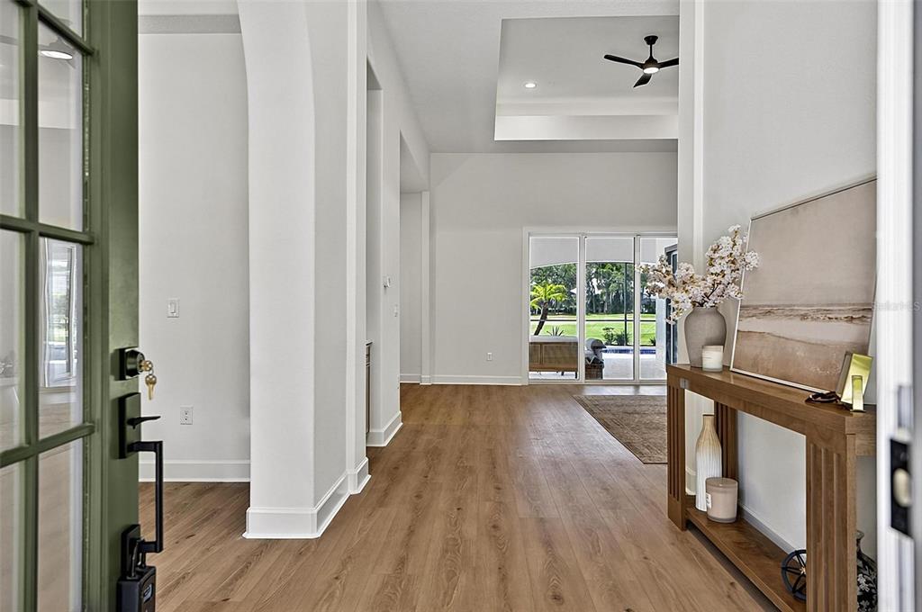 A bright entryway with wood-look flooring leads to an open living area with sliding doors — 21 EASTLAKE DRIVE, PALM COAST, FL