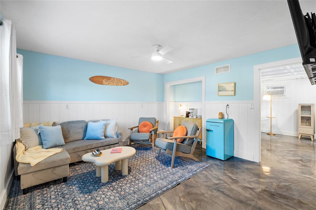 A living room features light blue walls, a surfboard wall decoration, and a blue refrigerator — 727 47TH STREET W, PALMETTO, FL