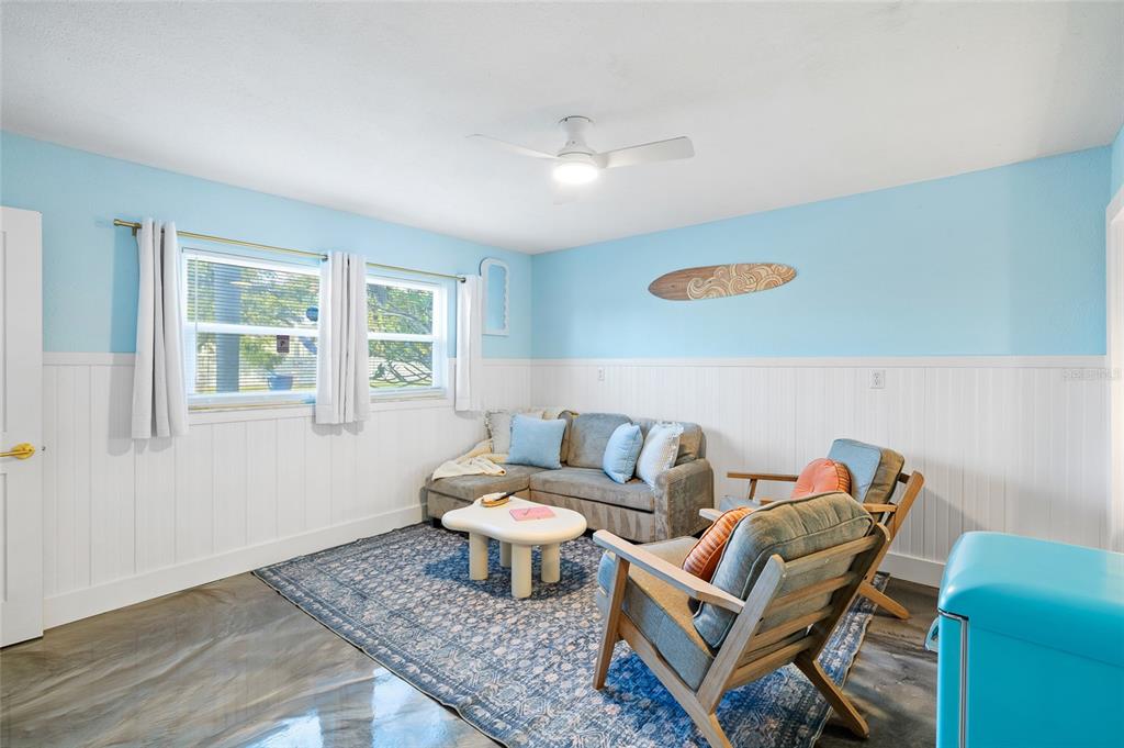 A living room features light blue walls, white wainscoting, a sectional sofa, and a patterned rug — 727 47TH STREET W, PALMETTO, FL