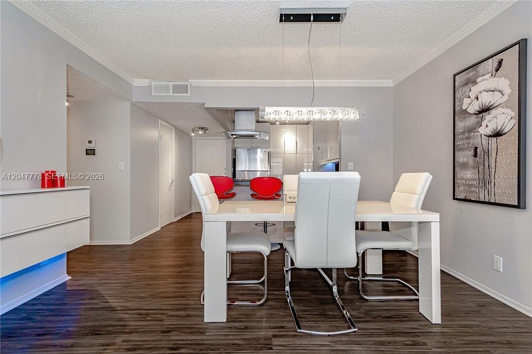 A dining area with a white table, four white chairs, and a modern light fixture — 200 Leslie Dr # 926, Hallandale Beach FL 33009, HALLANDALE BEACH, FL