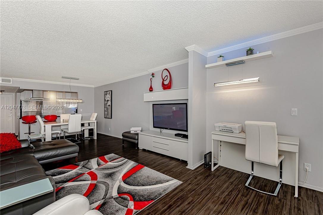 A living room features dark wood floors, a modern area rug, and a built-in media center — 200 Leslie Dr # 926, Hallandale Beach FL 33009, HALLANDALE BEACH, FL