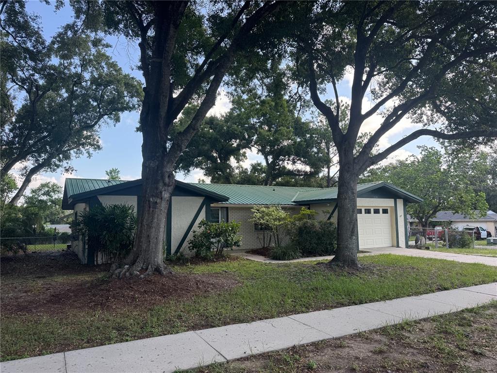 A single-story house with a green metal roof and a one-car garage — 624 WOOD ROAD, SEFFNER, FL