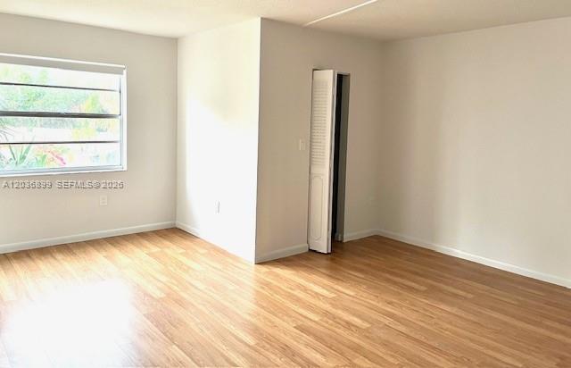 An empty room features light wood-look flooring, white walls, and a white louvered closet door — 3920 Inverrary Blvd # 204C, Lauderhill FL 33319, LAUDERHILL, FL