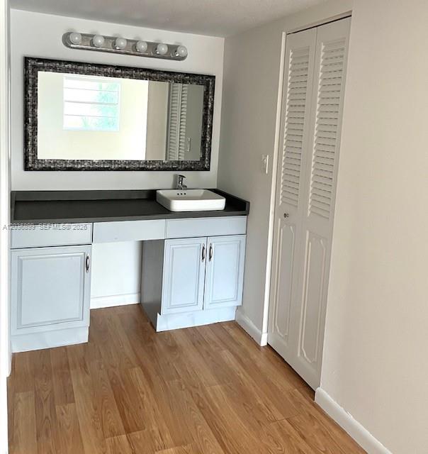 A bathroom vanity with a vessel sink, dark countertop, and a large framed mirror — 3920 Inverrary Blvd # 204C, Lauderhill FL 33319, LAUDERHILL, FL