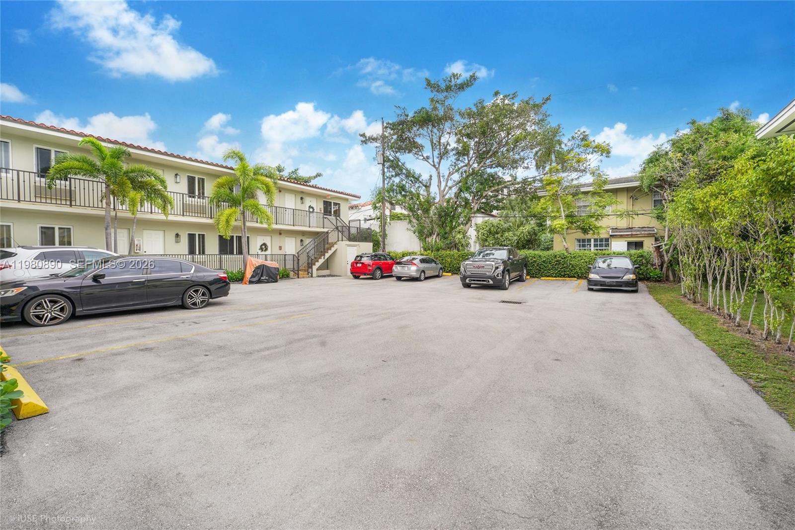 A paved parking lot sits in front of a two-story apartment building with palm trees — 35 Antilla Ave, Coral Gables FL 33134, CORAL GABLES, FL