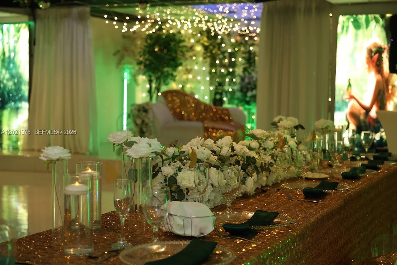 A long dining table with white floral centerpieces and gold sequin linens in a decorated room — 8250 SW flagler, Miami FL 33144, MIAMI, FL