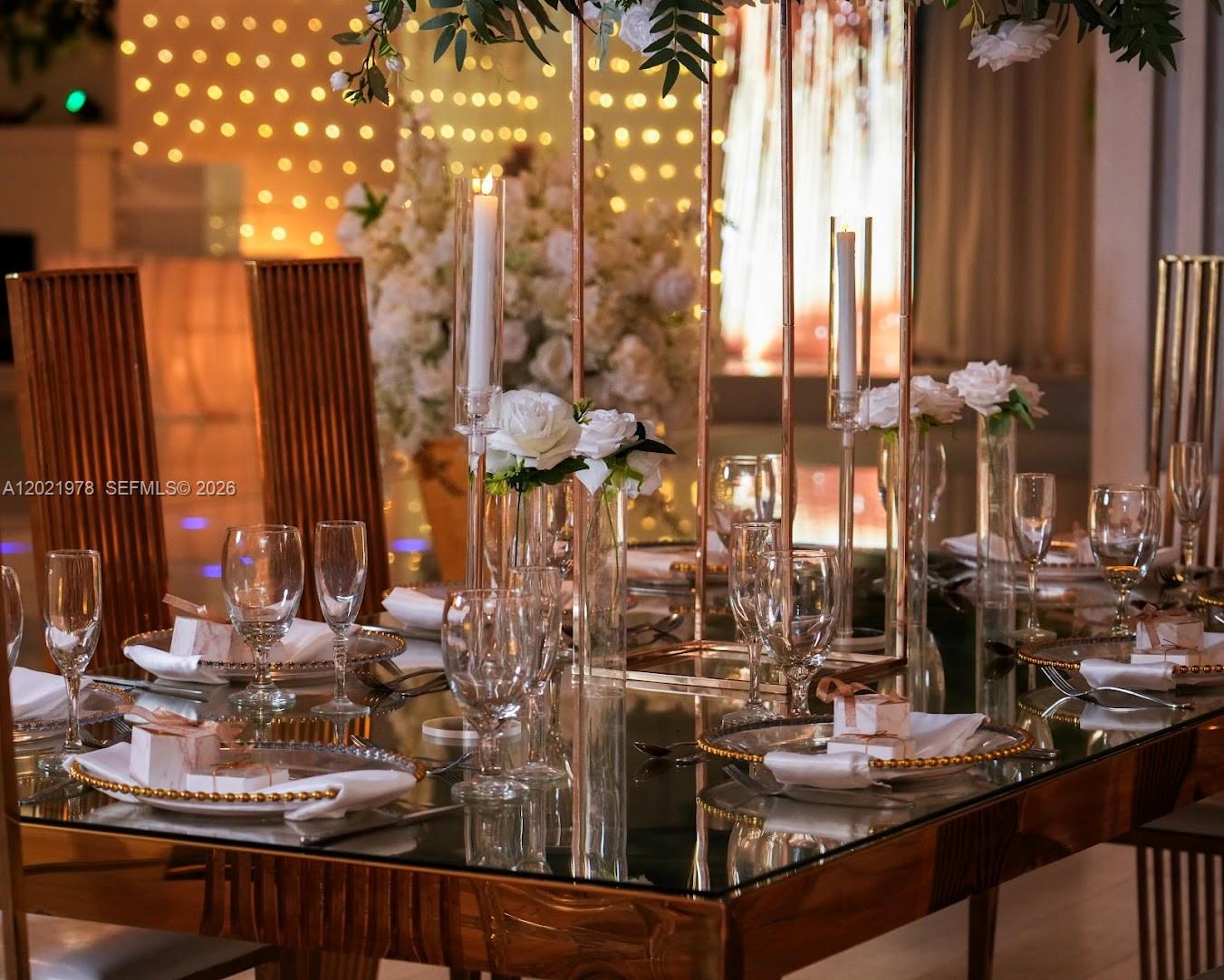 A formal dining table is set with glassware, white flowers, and tall candle holders — 8250 SW flagler, Miami FL 33144, MIAMI, FL