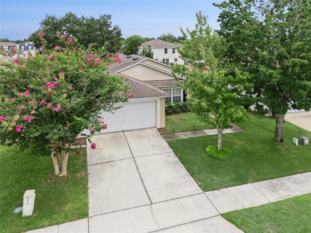 An aerial view of a suburban house with a concrete driveway and two large trees — 825 CLIFTON HILLS STREET, ORLANDO, FL