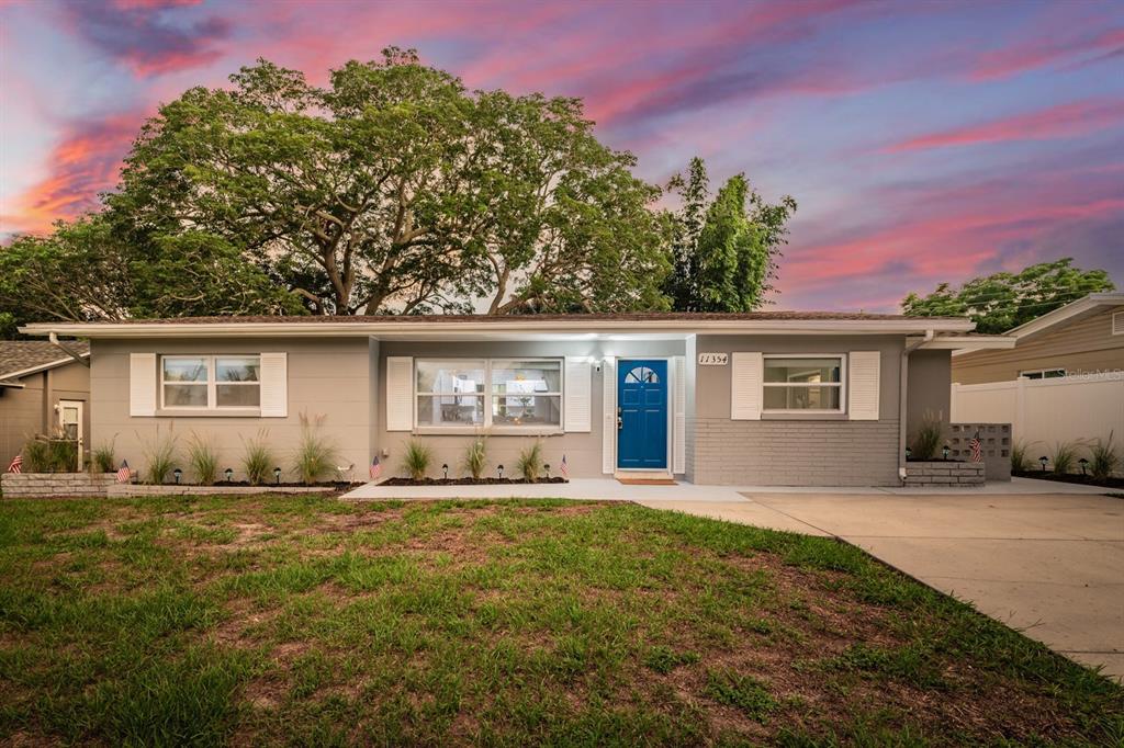 A single-story house with gray siding, a blue front door, and a small front porch — 11354 123RD TERRACE N, LARGO, FL