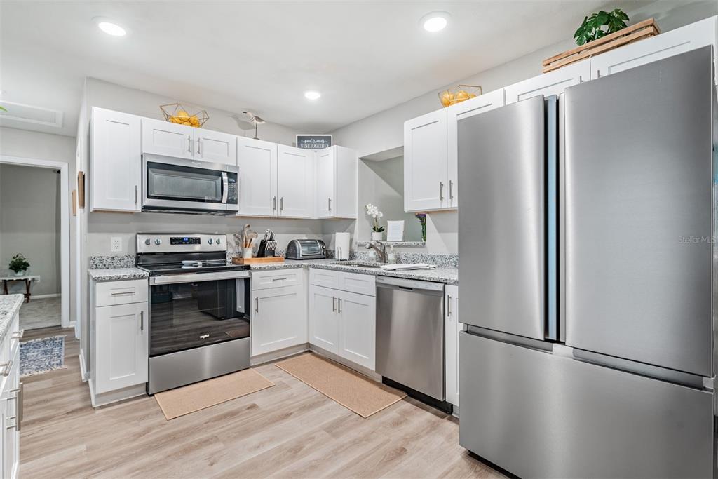 A front entrance features a blue door with a window, white shutters, and a welcome mat — 11354 123RD TERRACE N, LARGO, FL