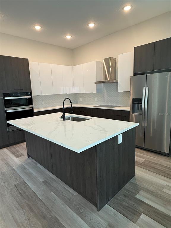 A modern kitchen features a large white quartz island, dark wood cabinetry, and stainless appliances — 820 46TH AVENUE N, ST PETERSBURG, FL