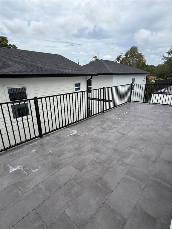 A rooftop deck features gray tile flooring and a black metal railing — 820 46TH AVENUE N, ST PETERSBURG, FL
