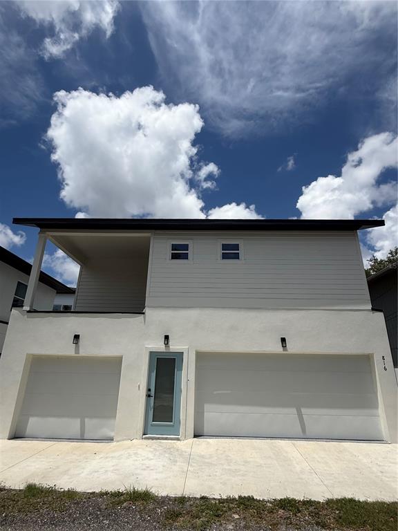 A two-story house exterior features a light-colored stucco base, two garage doors, and a balcony — 820 46TH AVENUE N, ST PETERSBURG, FL