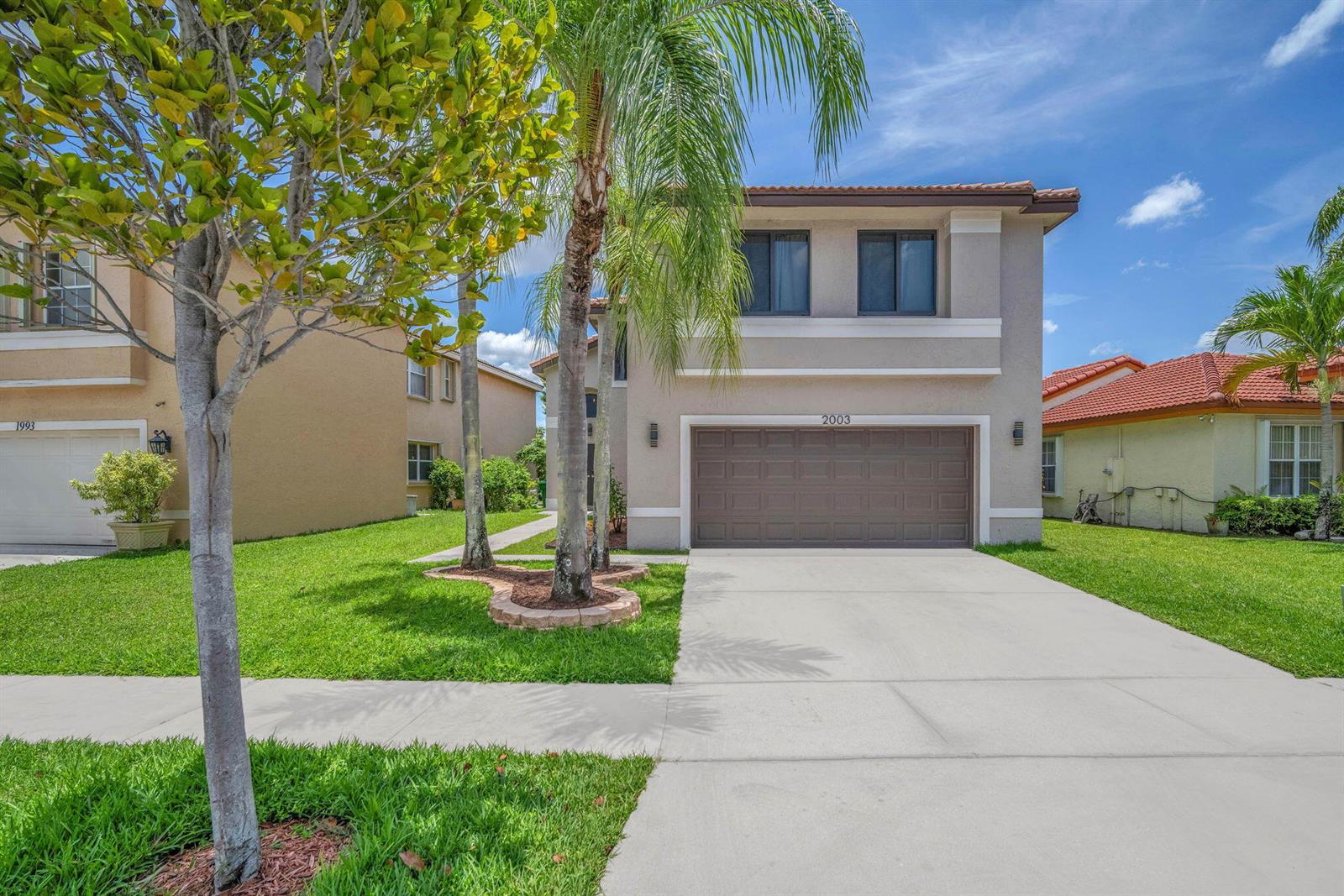 A two-story suburban house with a brown garage door, palm trees, and a concrete driveway — 2003 SW 173rd Avenue, Miramar FL 33029, MIRAMAR, FL