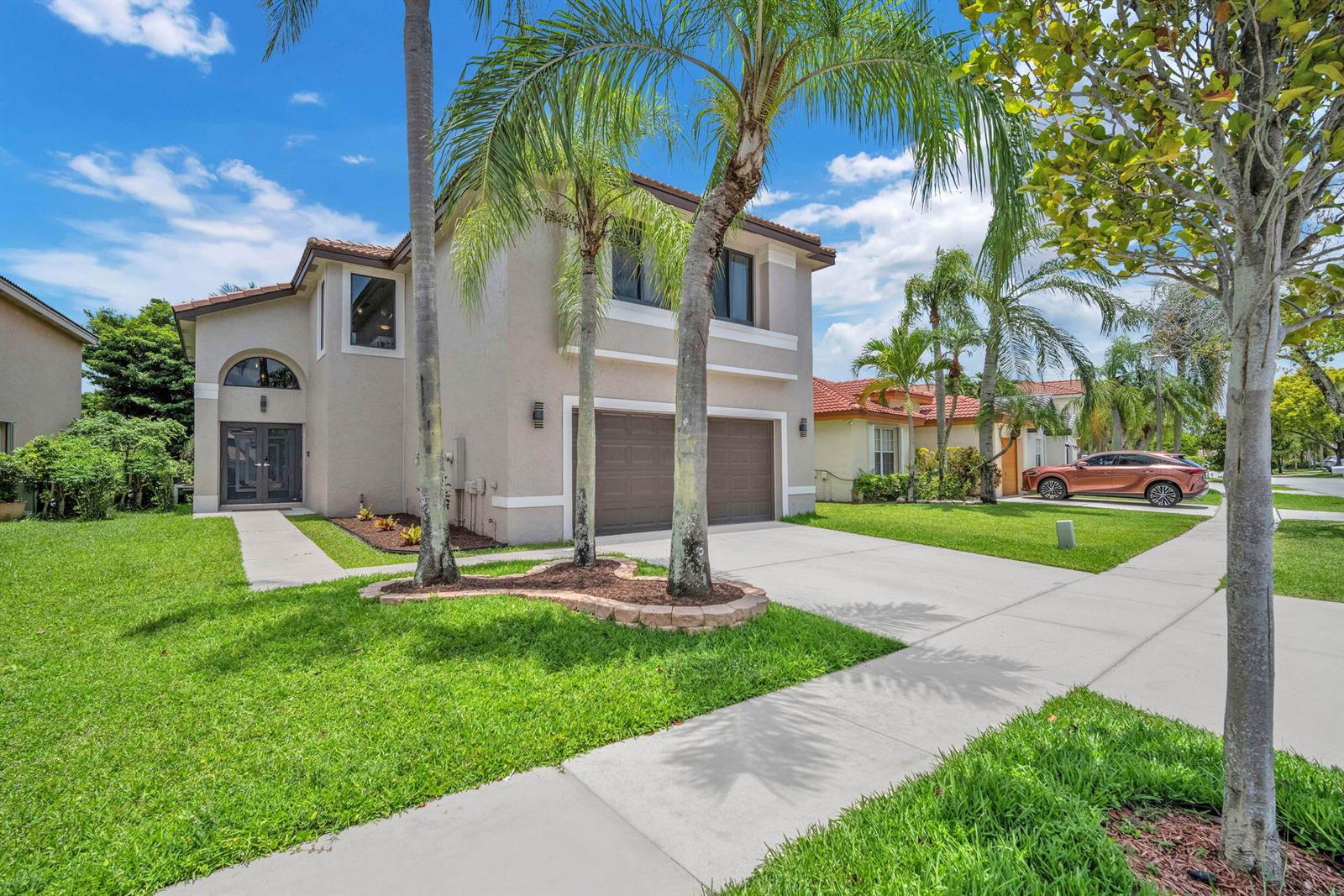A two-story beige house with a two-car garage and palm trees in the front yard — 2003 SW 173rd Avenue, Miramar FL 33029, MIRAMAR, FL