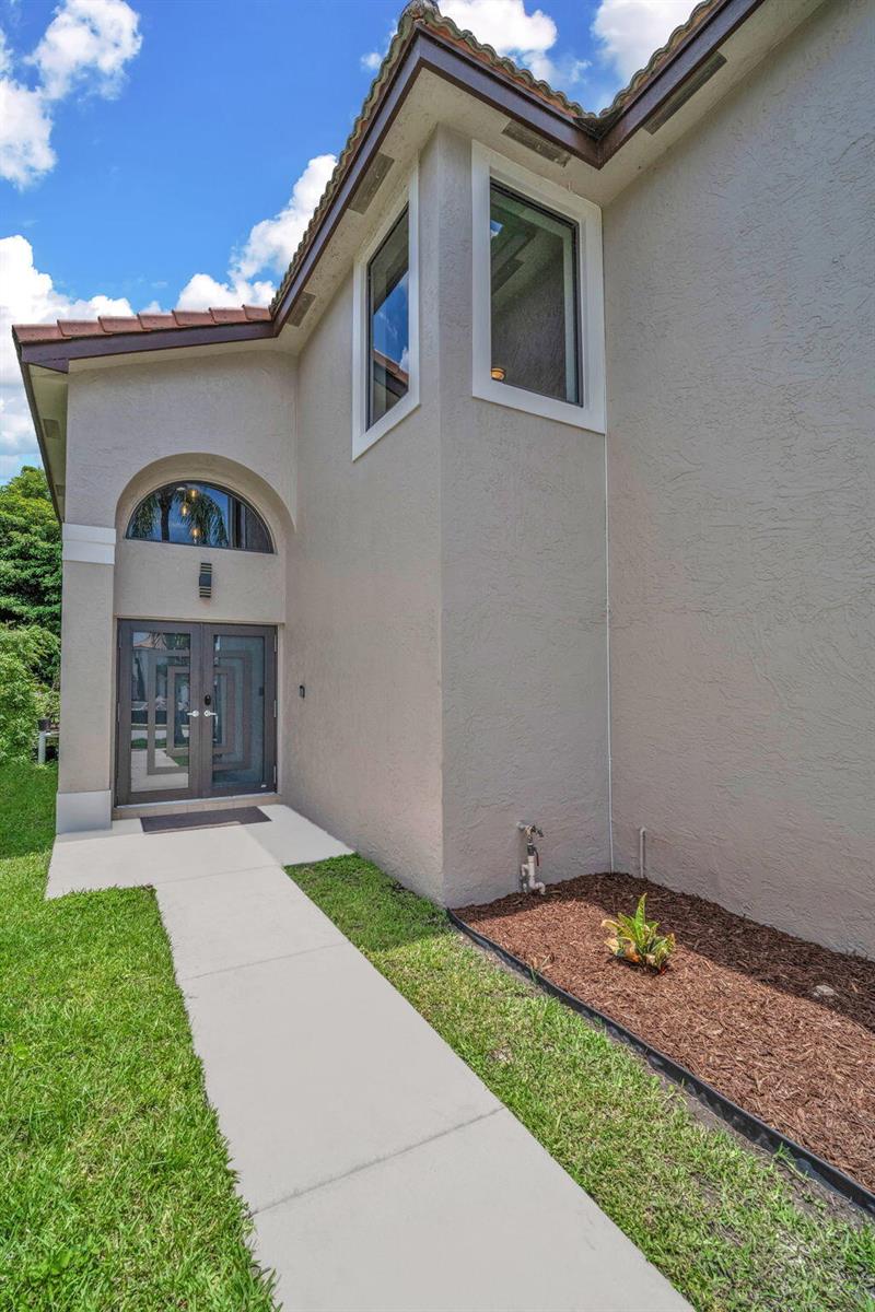 A concrete walkway leads to the double front doors of a beige stucco house — 2003 SW 173rd Avenue, Miramar FL 33029, MIRAMAR, FL