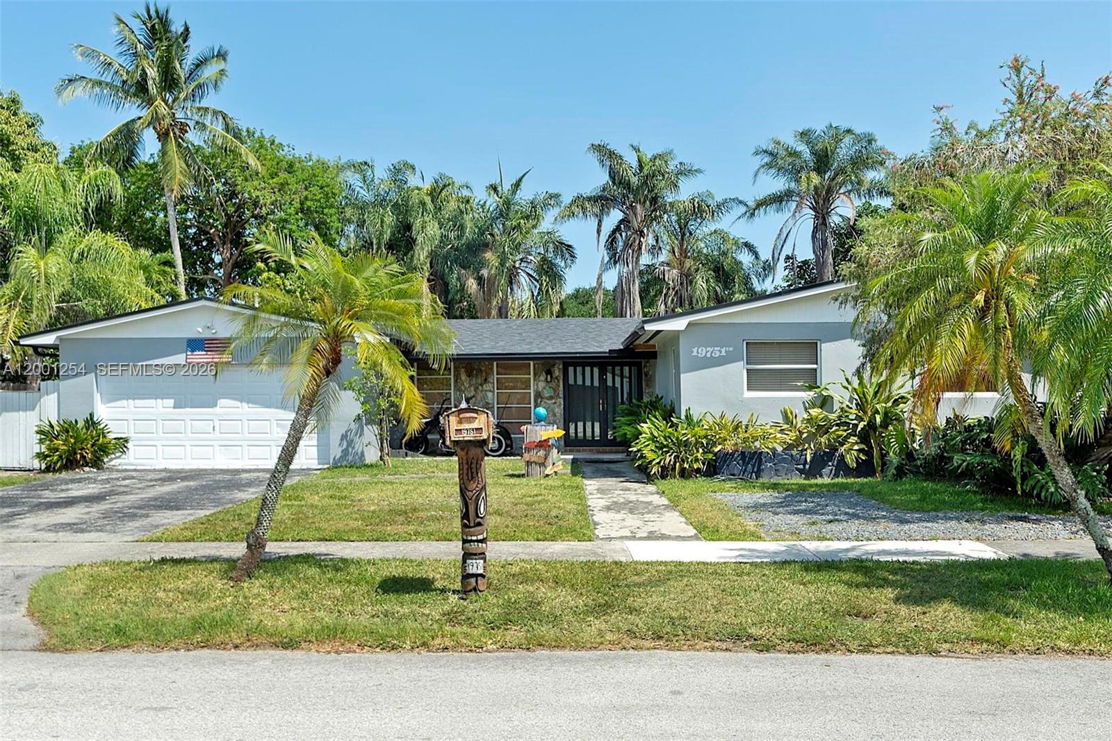 A single-story house with a white garage, palm trees, and a wooden tiki-style mailbox — 19751 SW 84th Ave, Cutler Bay FL 33189, CUTLER BAY, FL