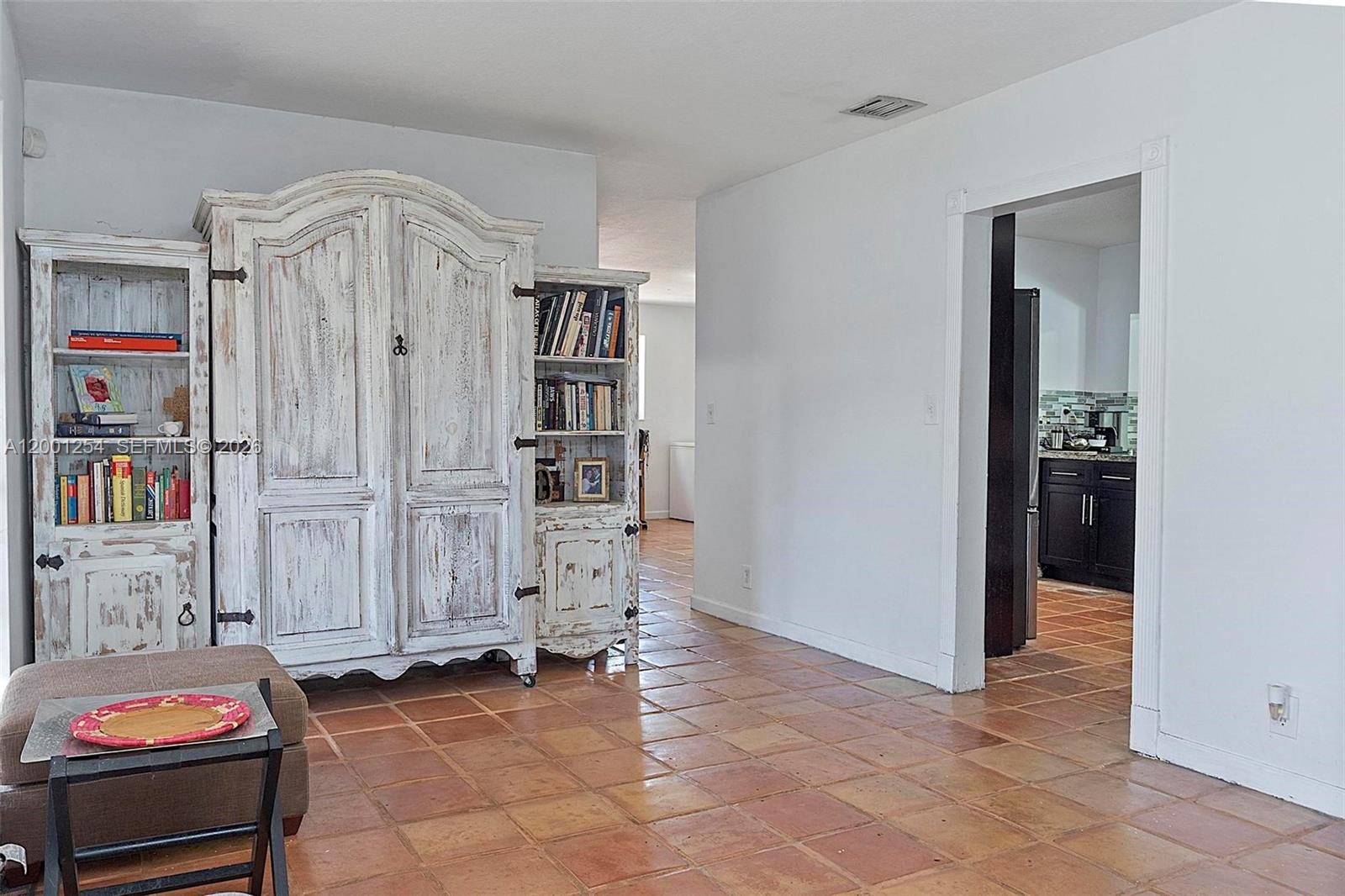 A living room features a large distressed white cabinet and terracotta tile flooring — 19751 SW 84th Ave, Cutler Bay FL 33189, CUTLER BAY, FL