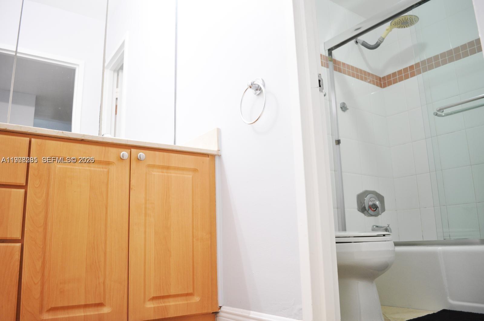 A bathroom features light wood cabinets, a white vanity top, and a shower-tub combination — 100 Lincoln Rd # 728, Miami Beach FL 33139, MIAMI BEACH, FL