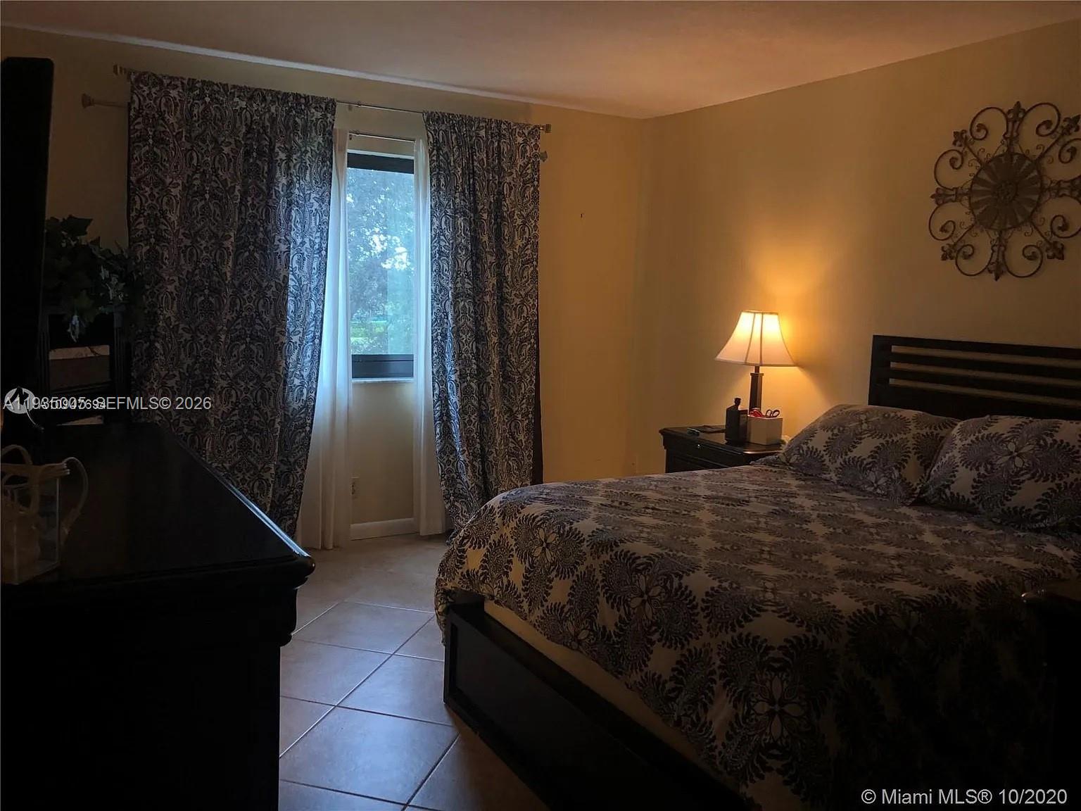 A kitchen features white cabinets, granite countertops, stainless steel appliances, and light-colored tile flooring — 9440 SW 8th St # 402, Boca Raton FL 33428, BOCA RATON, FL