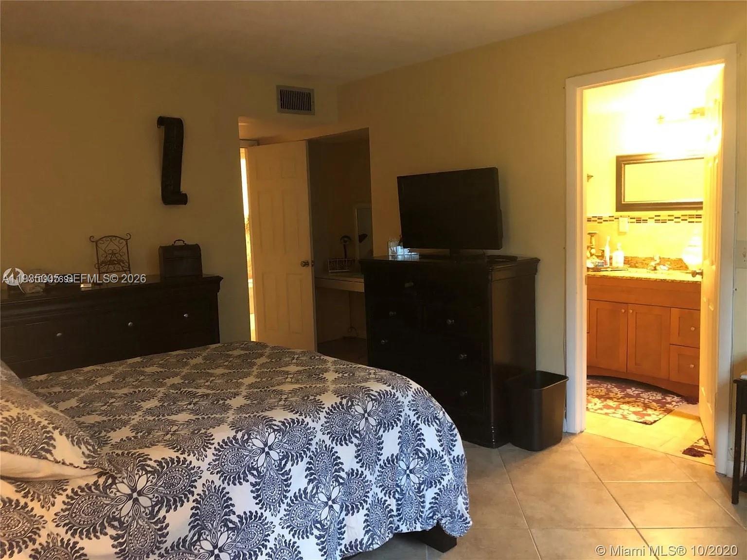A kitchen features white cabinets, stainless steel appliances, and granite countertops — 9440 SW 8th St # 402, Boca Raton FL 33428, BOCA RATON, FL
