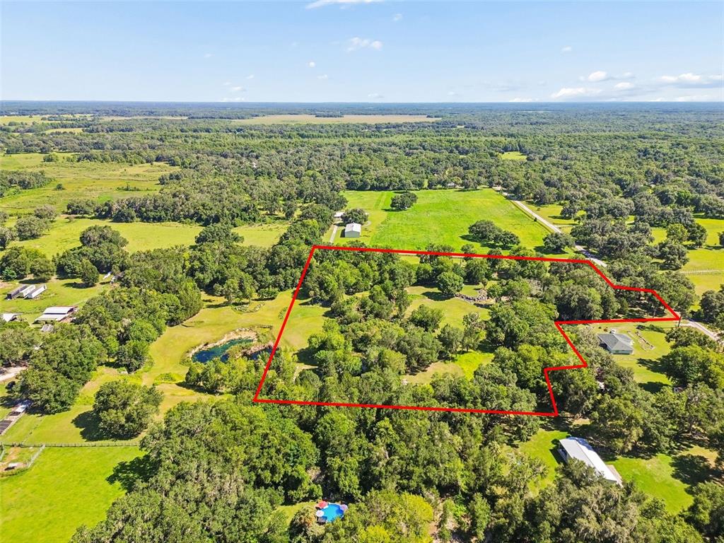 An aerial view shows a large, wooded plot of land outlined in red — 8792 S STEED TERRACE, FLORAL CITY, FL