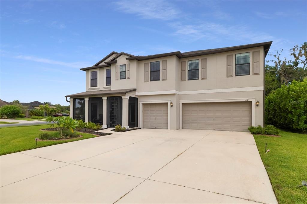 A covered entryway features a light-colored front door with a glass insert and rocking chairs — 6103 HORSE MILL PLACE, PALMETTO, FL