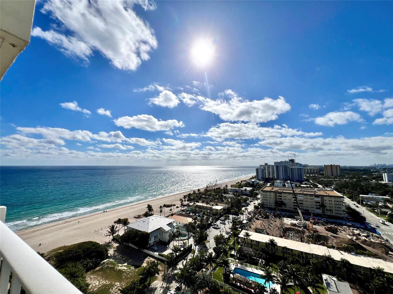 An elevated view of a sandy beach, ocean, and coastal buildings under a sunny sky — 111 Briny Avenue # 1908, Pompano Beach FL 33062, POMPANO BEACH, FL